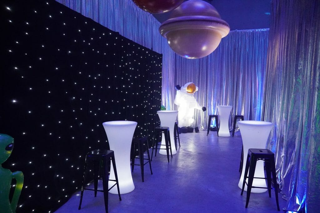 Star cloth and illuminated bar tables at space themed party top reasons for having a themed party