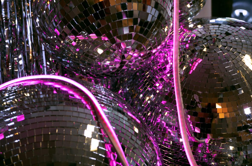 silver mirror balls, silver tinsel curtain, pink neon strip lighting