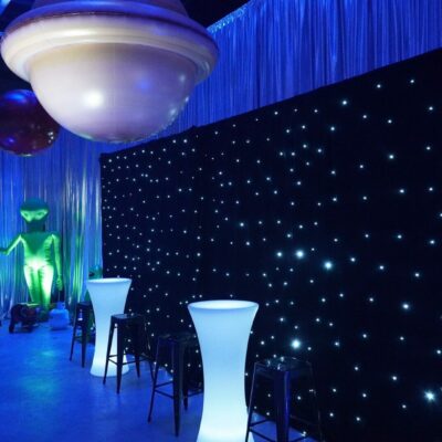 star cloth, illuminated furniture and inflatable planet at space themed party