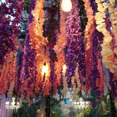 hanging artificial flowers in an enchanted garden themed event