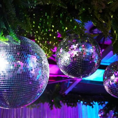 silver mirror balls and greenery at neon disco party theme