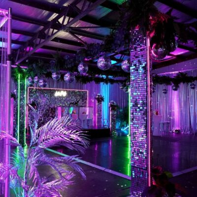 dance floor, mirror ball, sequin panels, greenery at neon disco themed party