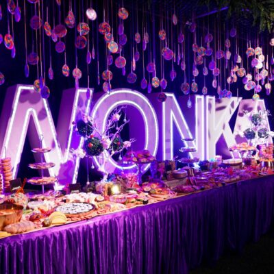 Grazing table at a candyland party with canapes, candy, pastries, and lollipops