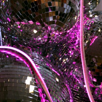 silver mirror balls, silver tinsel curtain, pink neon strip lighting