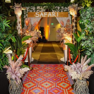 Safari themed entranceway with animal props, greenery,