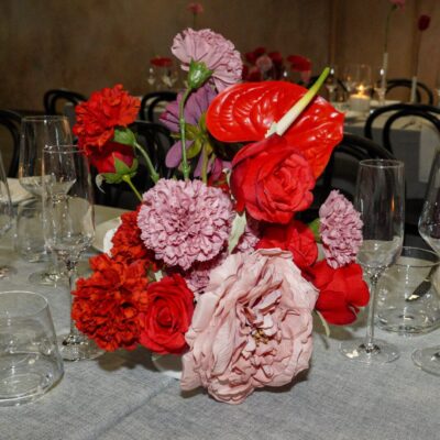 bold red and pink floral centrepiece at a styled wedding reception Table Décor