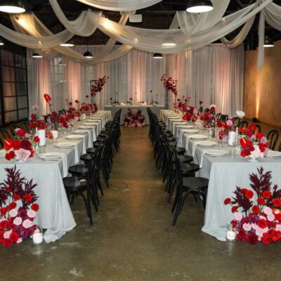 wedding planning services melbourne tables at a modern pink and red styled wedding reception featuring florals, linen, and white chiffon ceiling drape rock art events