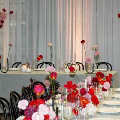 wedding decorating red and pink florals on the tables and bridal table of a modern styled wedding reception Episode 2: A Week at Feel Good Events