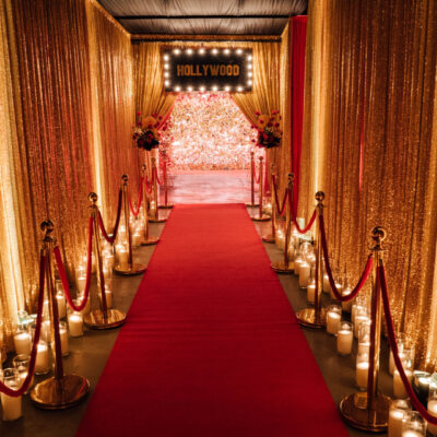 Hollywood themed entranceway with drape, red carpet, bollards, candles, and hollywood sign