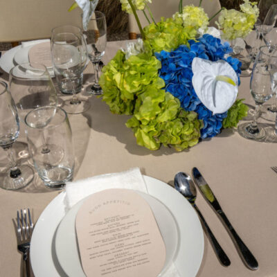 wedding reception table setting with stationary, bright florals