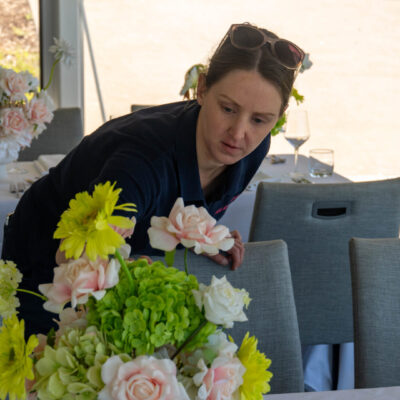 the role of a wedding stylist Claire placing florals on the table at wedding styled photoshoot