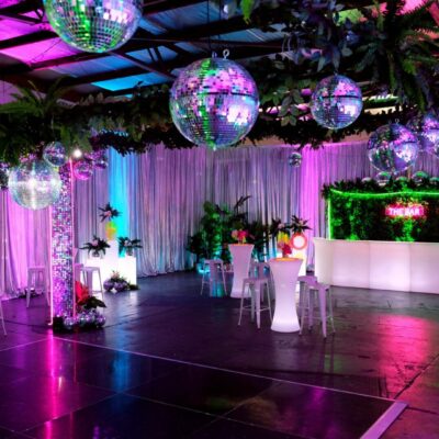 mirror balls, greenery, dance floor, neon lights, sequin panels at neon disco party theme