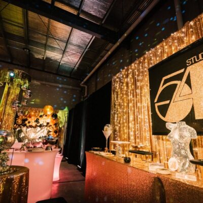 glamorous gold studio 54 themed party with themed props and gold draping From Empty Warehouse to Studio 54 Party