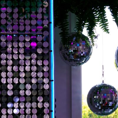 silver sequin panels, mirror balls, neon strips, greenery