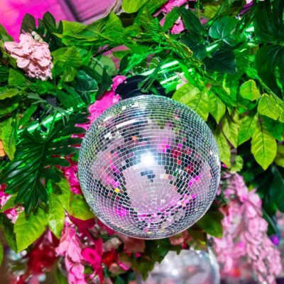 Silver mirror ball surrounded by tropical greenery and flowers